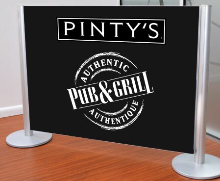 Tension fabric graphic stanchion printed with Pinty's Pub and Grill branding