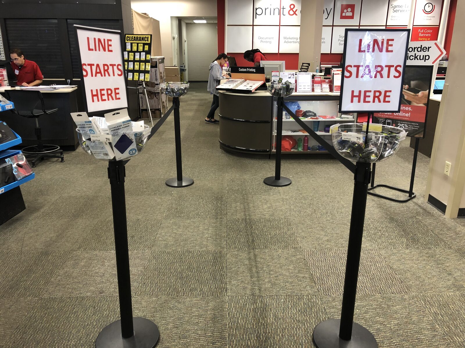 Stanchions with Line Starts Here signs and sanitizer bowls at retail checkout