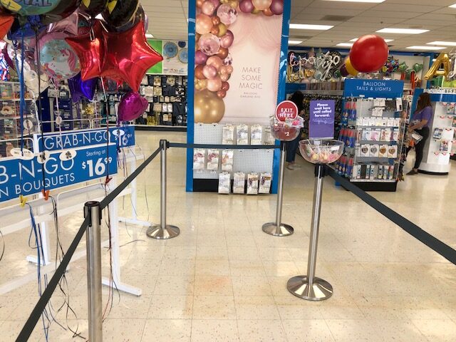 Chrome stanchion queue with impulse bowls and Enter Here round sign
