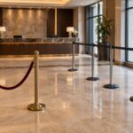 Hotel lobby showing post-and-rope stanchions at the entrance and retractable belt stanchions forming a check-in queue